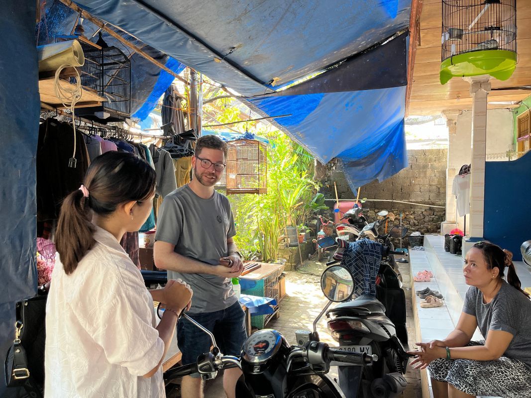 Tobias Schüßler im Gespräch mit der Projektleiterin Pradnya und einer Kleinstunternehmerin bei einem Hausbesuch nahe der Müllberge auf Bali.