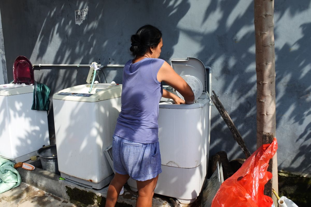 Frische grüne Bohnen, Erdnüsse auf dem Boden der Veranda, dazu eine Waage in welcher Bohne für Maemunahs täglichem Verkauf liegen. 