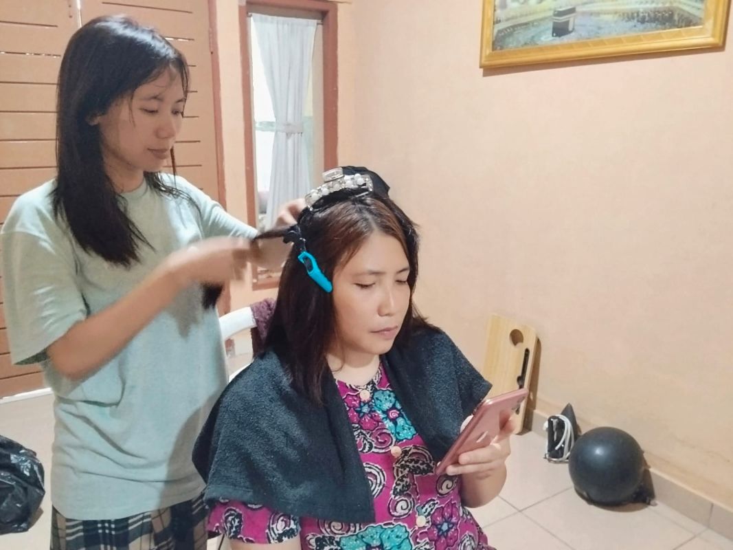 Maemunah im Gespräch mit einer Mitarbeiterin von Global Micro Initiative e.V. auf ihrer Veranda. 