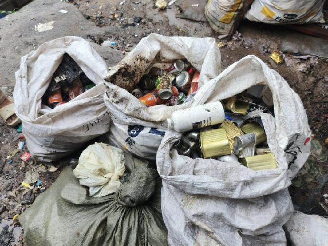 Frische grüne Bohnen, Erdnüsse auf dem Boden der Veranda, dazu eine Waage in welcher Bohne für Maemunahs täglichem Verkauf liegen. 
