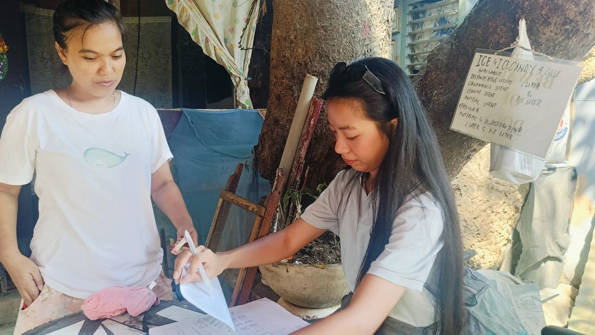 Frische grüne Bohnen, Erdnüsse auf dem Boden der Veranda, dazu eine Waage in welcher Bohne für Maemunahs täglichem Verkauf liegen. 