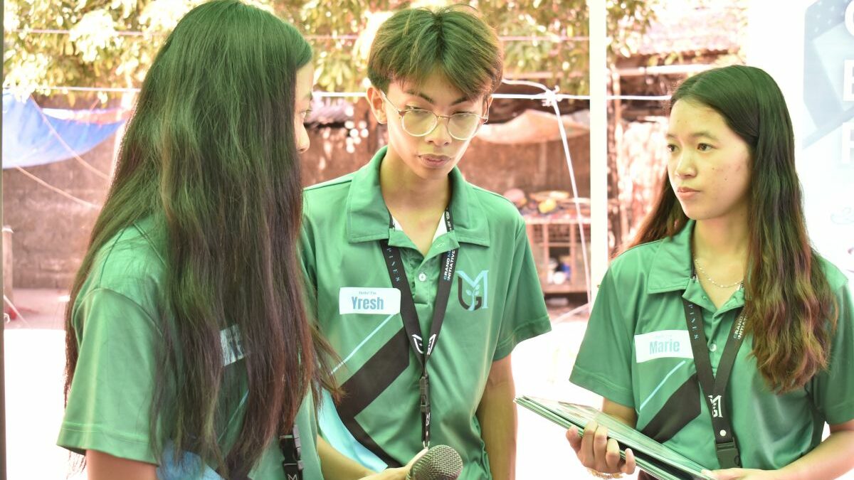 Drei Mitglieder des philippinischen Teams von Global Micro Initiative e.V. stehen beieinander und unterhalten sich.