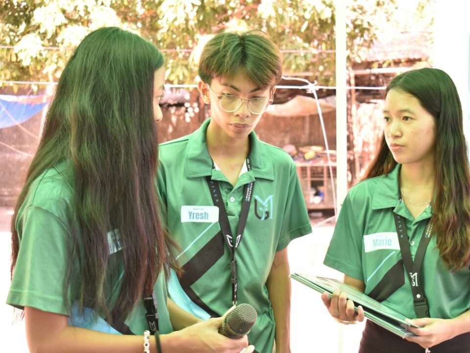 Drei Mitglieder des philippinischen Teams von Global Micro Initiative e.V. stehen beieinander und unterhalten sich.