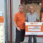 Vorstandsmitglied Achim steht zwischen zwei Personen aus dem Weltladen Karlstein e. V., die einen Spendenscheck halten.