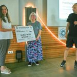 Eine Frau überreicht Silvia von Global Micro Initiative e.V. einen Spendenscheck über 1.000 Euro von WE-FOR-FUTURE e. V.